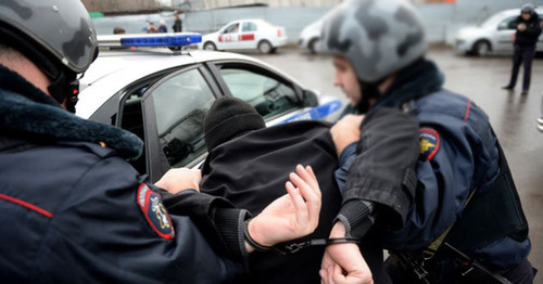 Policemen detain a person. Photo: Kiril Kalinikov (RFE/RL)