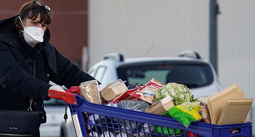 A woman in a medical mask buying food products. Photo: REUTERS/Pascal Rossignol