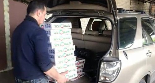 A volunteer loads foodstuff parcels for those in need in a car. Photo by Lyudmila Maratova for the "Caucasian Knot"