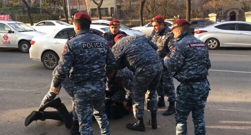 Policemen detain a man. Screenshot of video posted at Ishkhan Sagatelyan's Facebook page