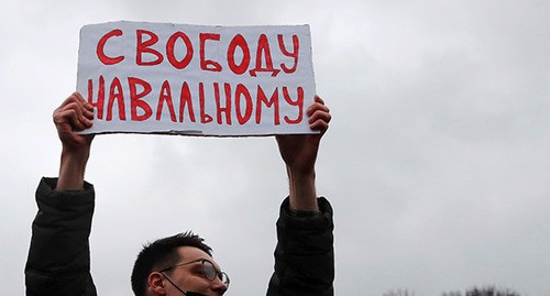 A protestor holding banner in support of Alexei Navalny. Abstract illustration. Photo: REUTERS/Anton Vaganov