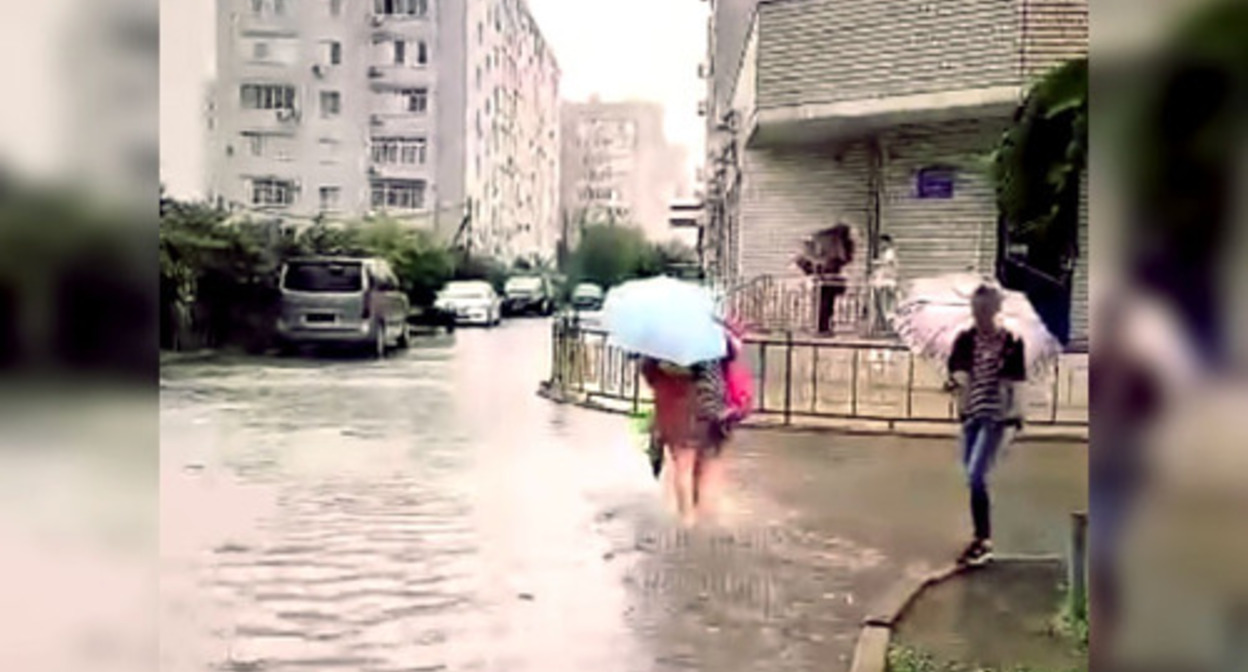 A resident of Krasnodar walks along a flooded street. Image made from video posted at: https://vk.com/wall-33025155_10315557