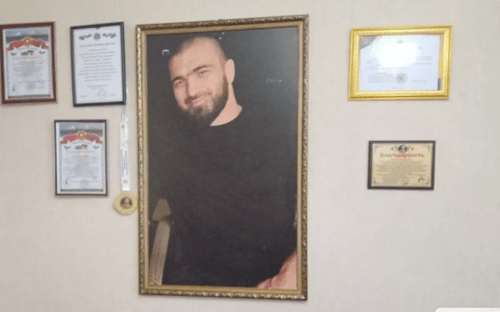 Kurban Dalgatov's photo at his parents' home. Photo by the "Chernovik" outlet https://chernovik.net/news/zakryl-kurtkoy-obzor-videokamery-i-telo-kurbana-potaschili-vniz