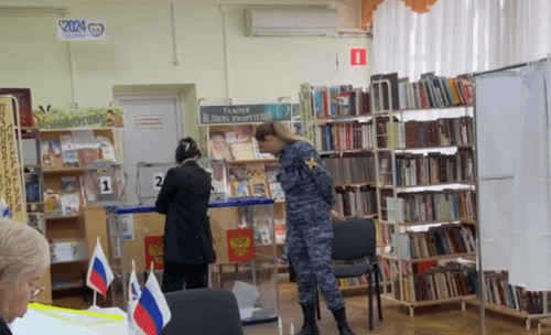 A "Rosgvardiya" (Russian National Guard) fighter standing next to the ballot box at a polling station in Krasnodar. Screenshot of the video published on the website of the "Map of Election Violations" project on March 17, 2024 https://www.kartanarusheniy.org/messages