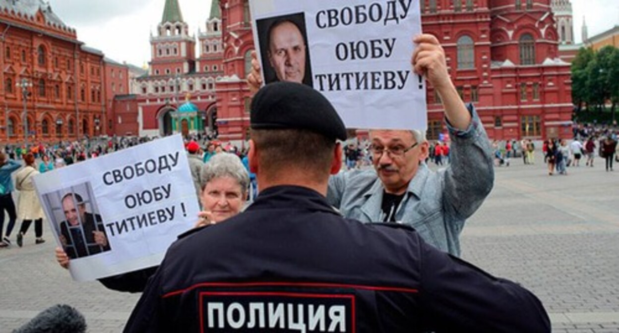 A law enforcer talks to Svetlana Gannushkina* and Oleg Orlov* at a picket in defence of Oyub Titiev. Moscow, July 2018. Photo: Viktoriya Odissonova / "Novaya Gazeta" is included into the register of foreign agents